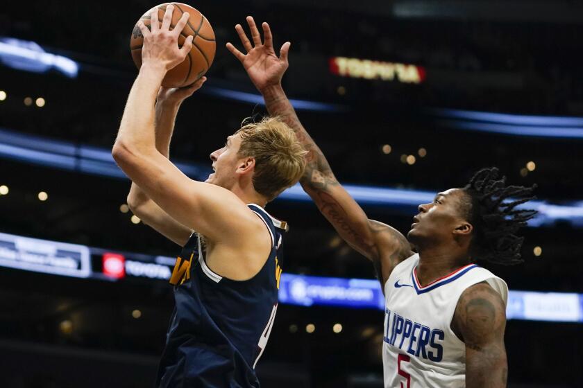 Denver Nuggets forward Hunter Tyson, left, shoots as Los Angeles Clippers guard Bones Hyland defends during the first half of an NBA preseason basketball game, Thursday, Oct. 19, 2023, in Los Angeles. (AP Photo/Ryan Sun)