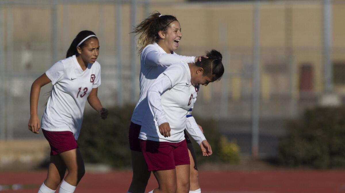 Ocean View High senior captains Kaci Montoya, center, and Daisy Moran, right, celebrate a goal during the first half against Loara in Huntington Beach on Thursday. Moran assisted Montoya for a point.