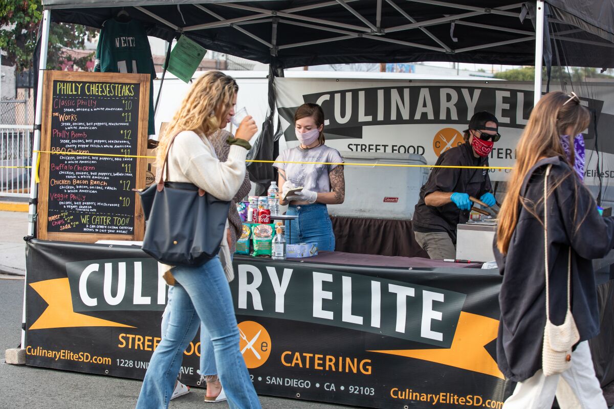Marissa Kastelic and Kelin Jones of Culinary Elite Street Food & Catering work their booth at the Ocean Beach Farmers Market.