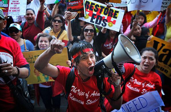 Protesters for adult education yell out against education cuts along with several other groups outside of the LAUSD's downtown Los Angeles headquarters.