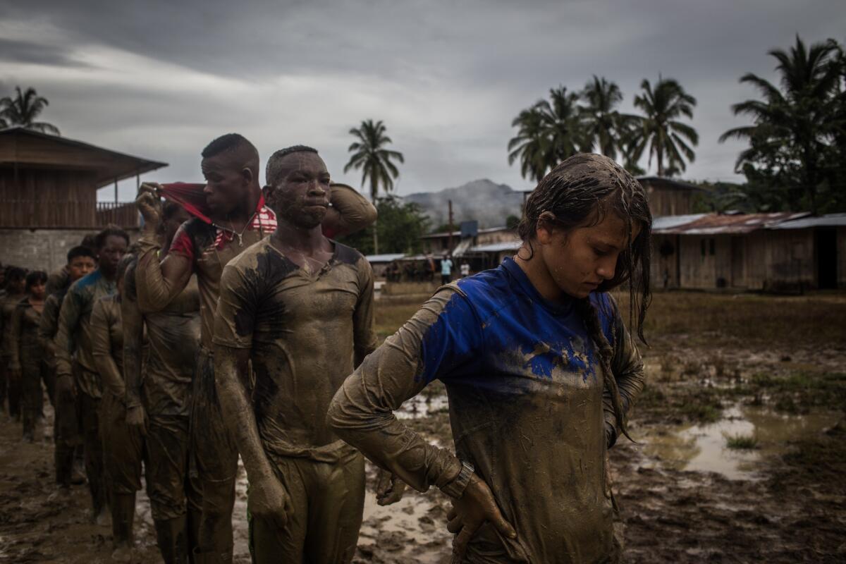 A muddy soccer field serves as a site for combat training.