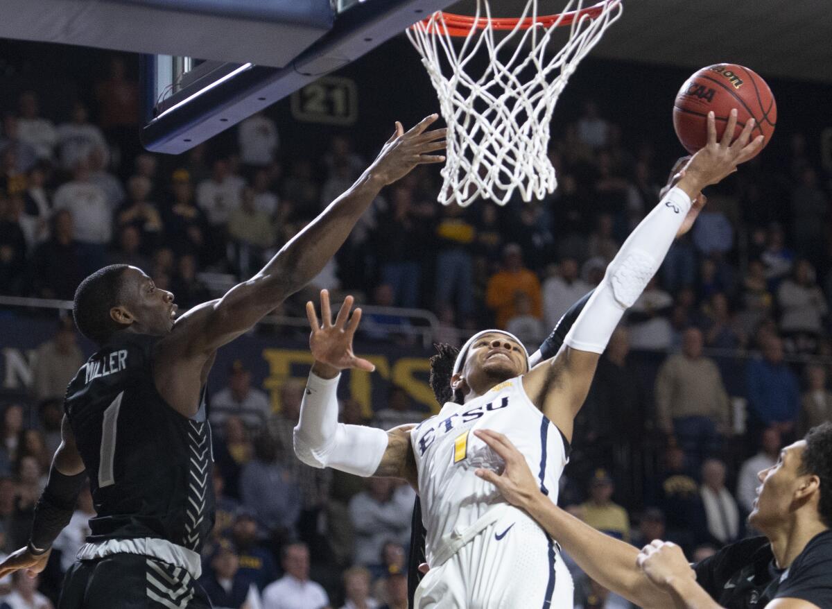 East Tennessee State's Tray Boyd III shoots against UNC Greensboro's Isaiah Miller during a game on Feb. 1.