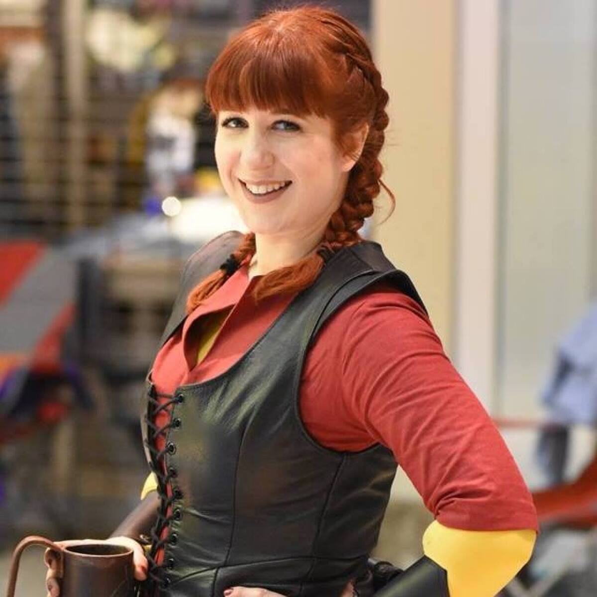 A woman with braided red hair wearing a medieval costume