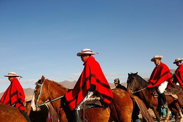 Soldiers wearing ponchos escort Bolivia's President Evo Morales, unseen, during a cavalcade in Patacamaya, Bolivia. The horse cavalcade is scheduled to arrive on July 16 at La Paz to celebrate Bolivia's 200 years of independence.