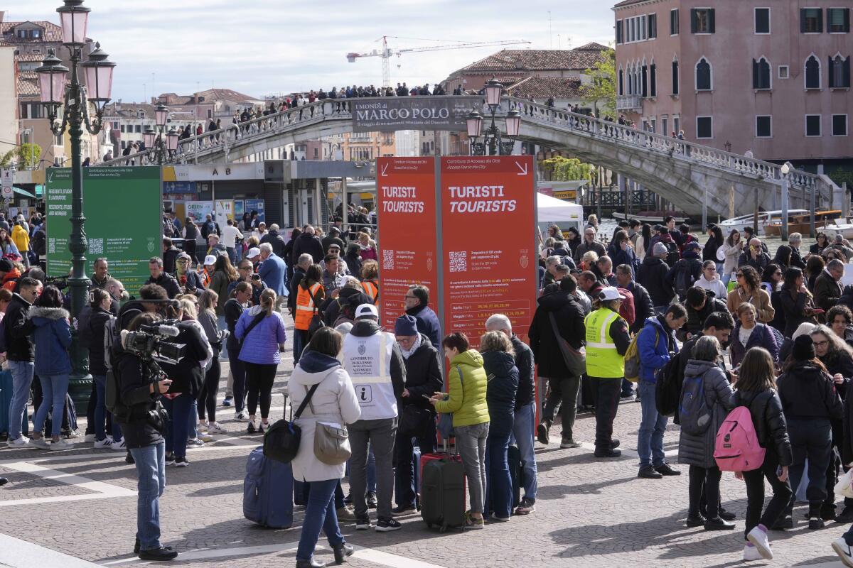 Stewards check tourists QR code access outside the main train station in Venice, Italy.