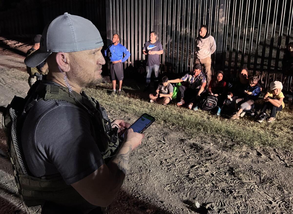 Samuel Hall, North Texas-based founder of the Patriots for America militia, surveys migrants stopped by border agents