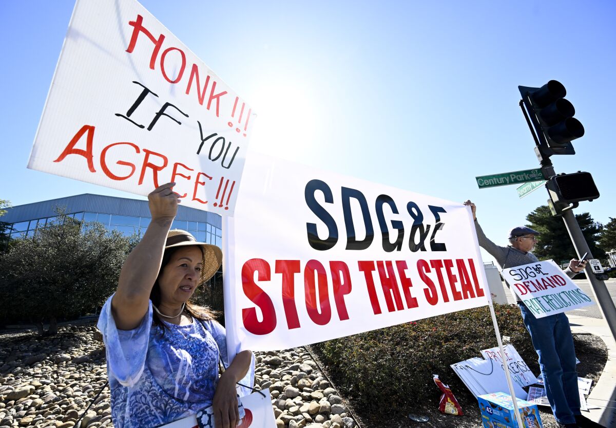 Amy Le, izquierda, y Richard Niwinski protestan ante la sede de SDG&E el lunes.