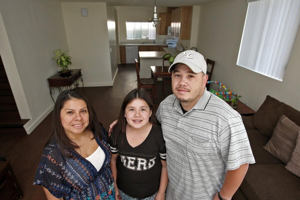 Evelyn, Genesis and Douglas Villalta stand in the living room of their new townhome in Burbank's newest affordable housing project on Monday, August 19, 2013.