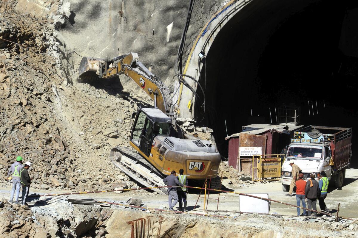 Heavy machinery works at the the entrance to an under-construction road tunnel.