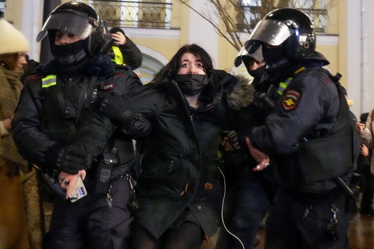 Police officers arrest a woman in St. Petersburg, Russia.