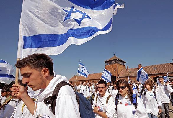Marchers hold up Israeli flags as they arrive in the death camp of Auschwitz-Birkenau to mark the annual Holocaust remembrance in Oswiecim, Poland, on Tuesday during the annual "March of the Living." The event, which commemorates the 6 million Jews who perished in the Holocaust, was launched in 1988, drawing thousands of people from around the world, from Jewish youngsters to elderly Holocaust survivors. Organizers estimated that half of the 8,000 people who gathered this year were not Jewish.