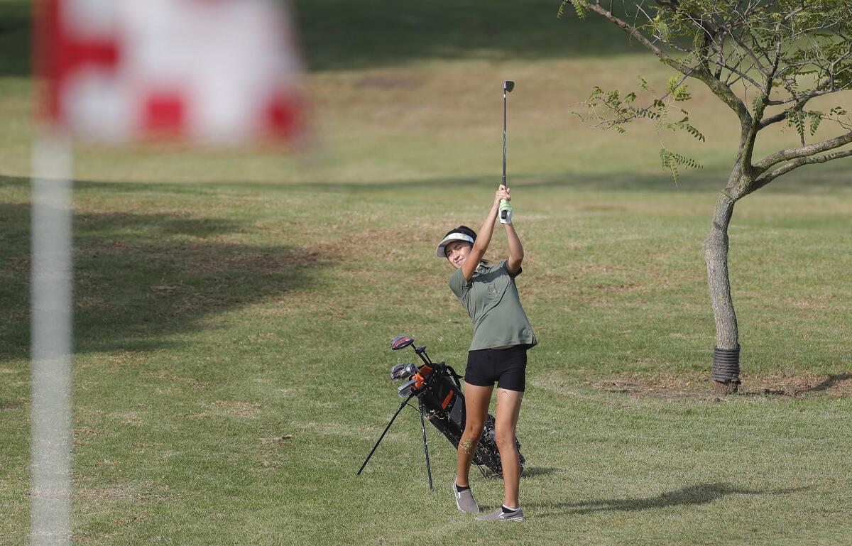 Costa Mesa's Izzy Flores hits to the green during the Battle for the Bell golf match against Costa Mesa on Wednesday.
