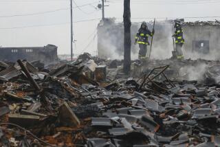 Firefighters look at the rubble and wreckage of a burned-out marketplace after a large fire caused by earthquakes in Wajima, Ishikawa prefecture, Japan Wednesday, Jan. 3, 2024. (Kyodo News via AP)