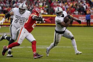 Raiders running back Zamir White (35) tries to evade Chiefs safety Mike Edwards.