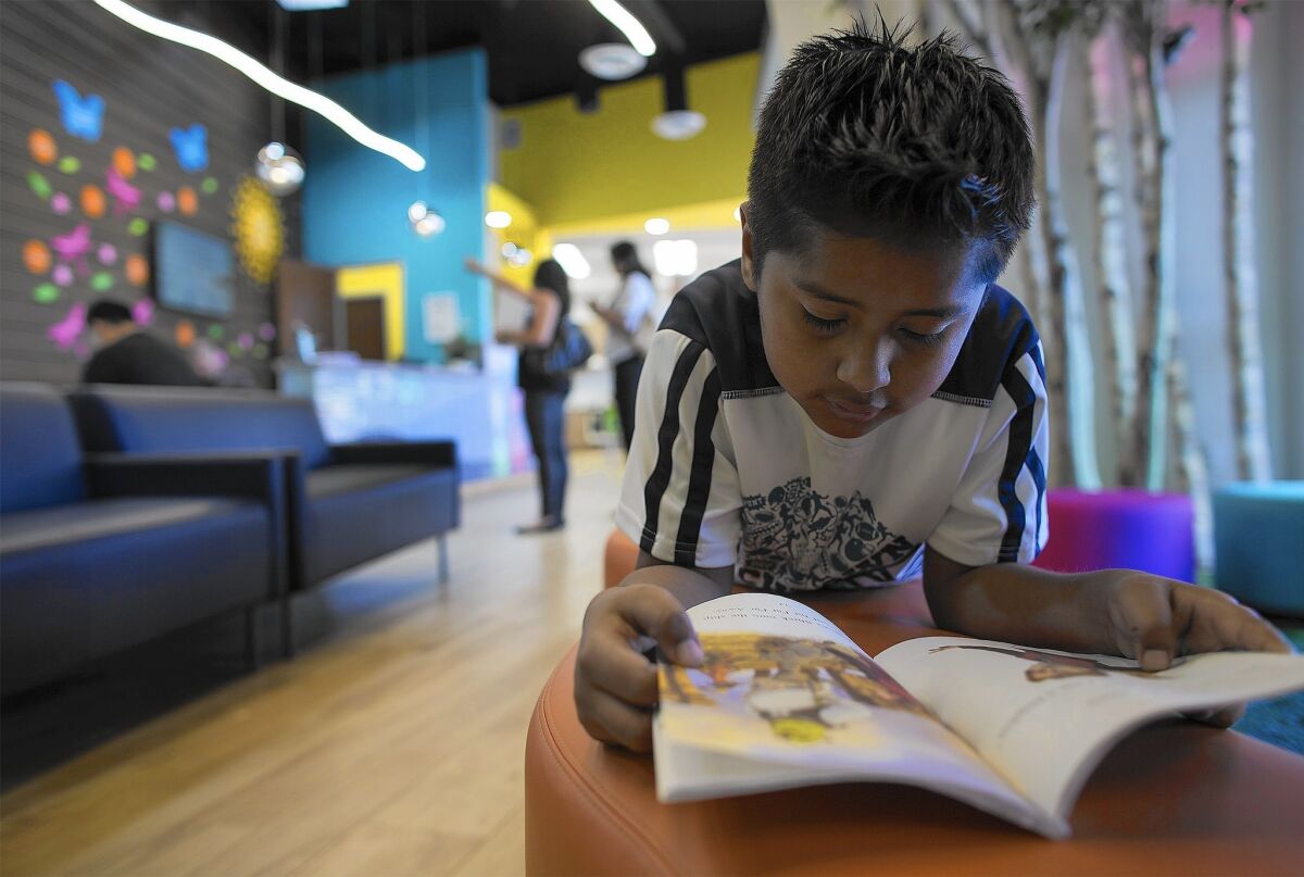 Fernando Hernandez, 8, of Los Angeles, reads a book while waiting for his doctor appointment at the new Lou Colen Children's Health & Wellness Center.