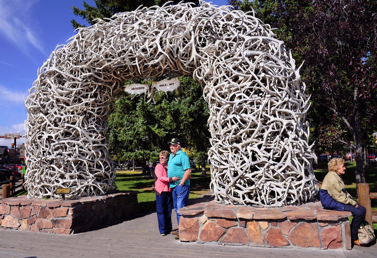 Tourists pose for a photograph in front of one of four elk antler arches at the entrances to George Washington Memorial Park in Jackson Hole, Wyoming.