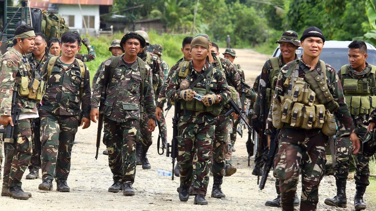 Philippine soldiers patrol a road at Pigkawayan, a farming town about 100 miles from Marawi in the southern Philippine island of Mindanao on June 21.