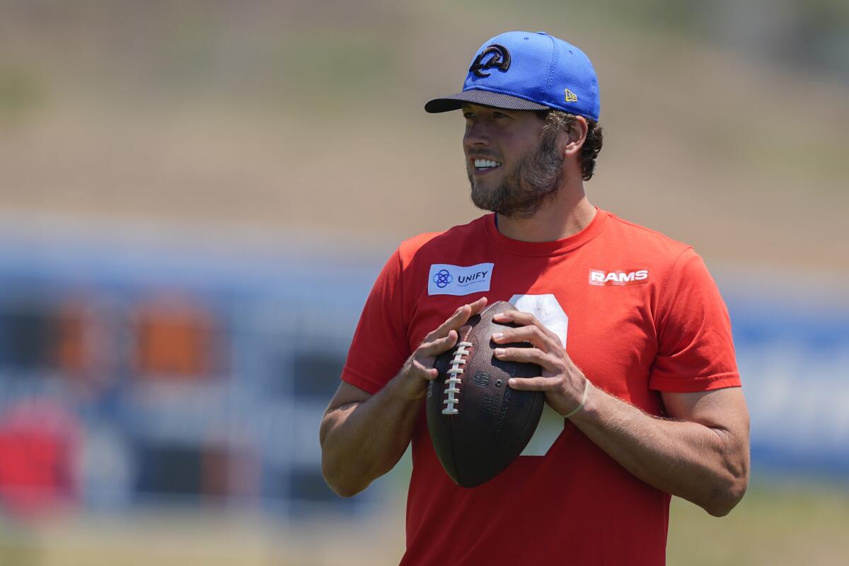 Rams quarterback Matthew Stafford holds a football as he watches practice.