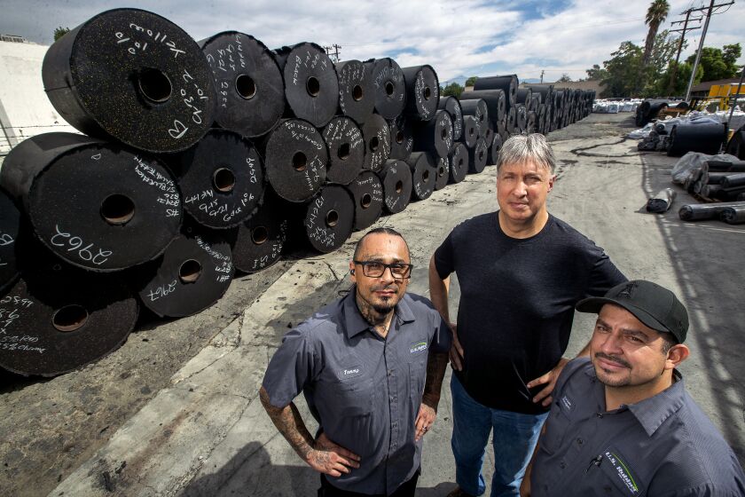 Thomas Urioste and Carlos Arceo, former felons and employees at U.S. Rubber Recycling, with CEO Jeff Baldassari, center.