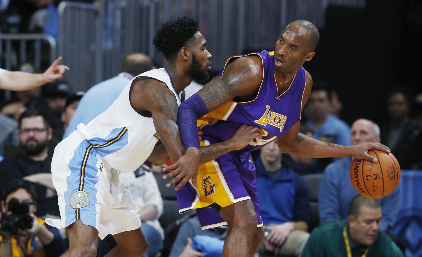 Los Angeles Lakers forward Kobe Bryant, right, works the ball inside for a shot as Denver Nuggets forward Will Barton defends during the second half on Tuesday.