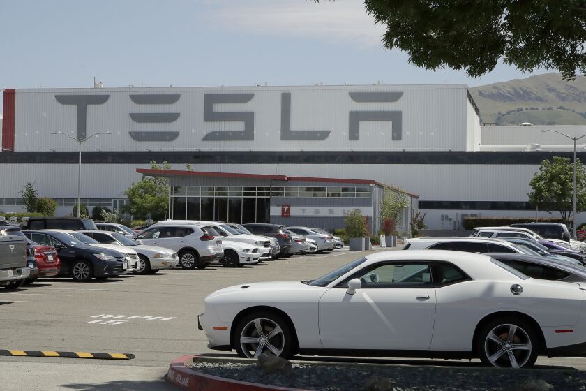 Vehicles are seen parked at the Tesla car plant Monday, May 11, 2020, in Fremont, Calif. The parking lot was nearly full at Tesla's California electric car factory Monday, an indication that the company could be resuming production in defiance of an order from county health authorities. (AP Photo/Ben Margot)