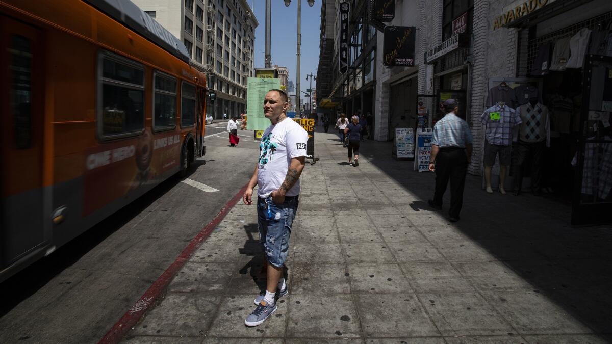 Byron Wade Taylor waits for the No. 2 Metro bus in downtown L.A. on Friday to get to his job at Gwen restaurant in Hollywood. The route connects some of the city's richest ZIP codes to some of its poorest.