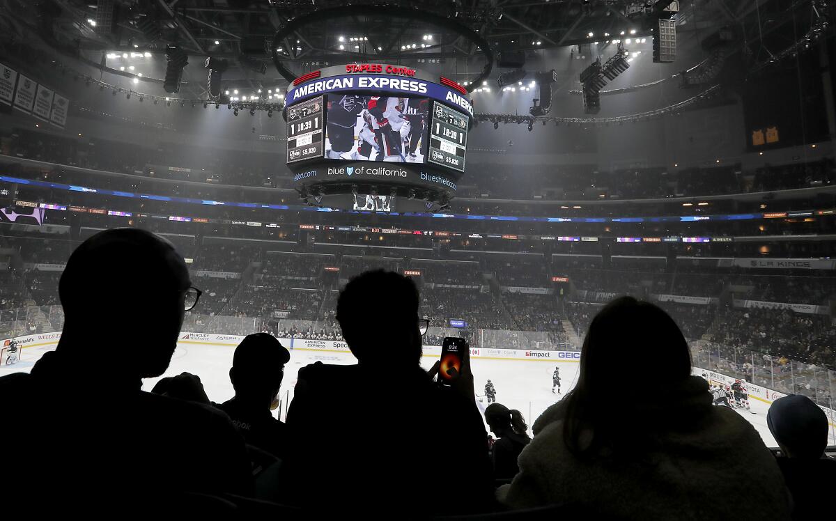 Hockey fans watch a game between the Los Angeles Kings and Ottawa Senators at Staples Center.