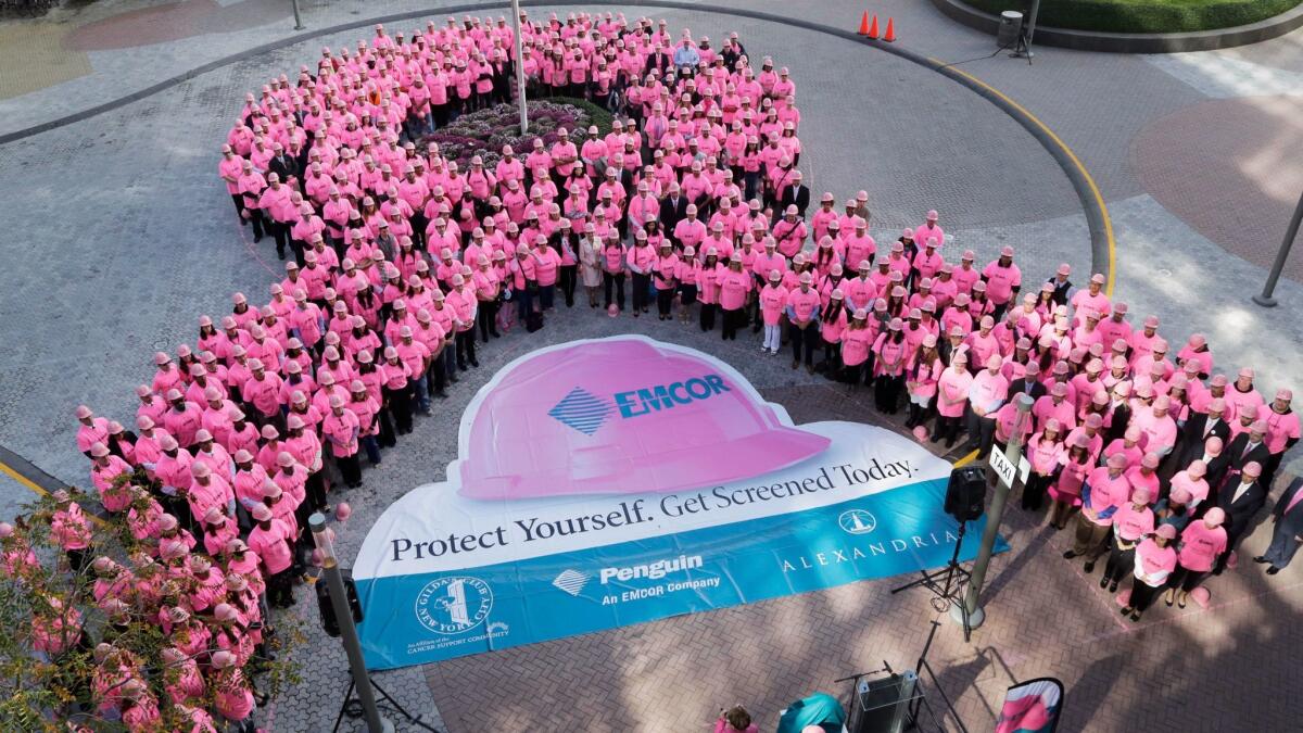 Hundreds of New Yorkers wearing pink hard hats and pink shirts form a pink ribbon in honor of Breast Cancer Awareness Month on Oct. 7, 2014 in New York.