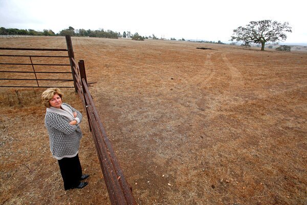 Sharon Currie, 53, president of the Santa Ynez Valley Assn. of Realtors, stands next to an entrance to the 1,400-acre parcel known as Camp 4 owned by the Santa Ynez Band of Chumash Indians in Santa Ynez, Calif.