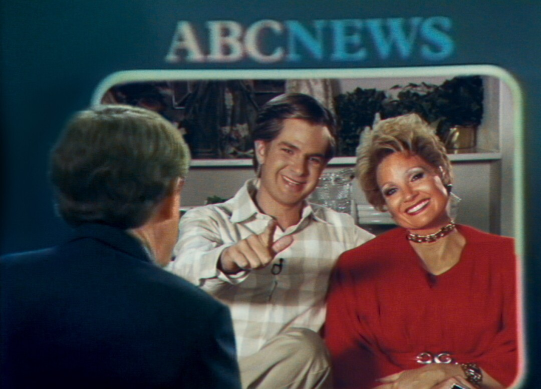 A man and a woman smiling on a TV screen