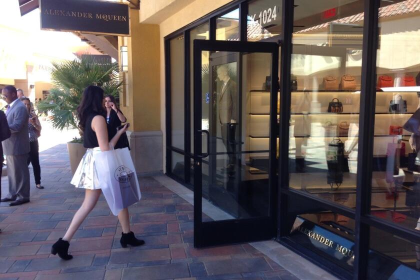 A shopper heads into the new Alexander McQueen store at the Desert Hills outlet mall.