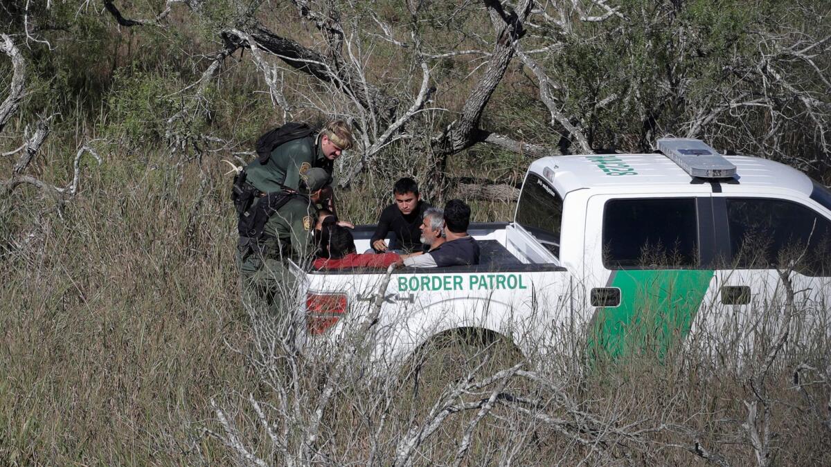Border Patrol agents stop people suspected of illegally entering the U.S. through a ranch near Edinburg, Texas.