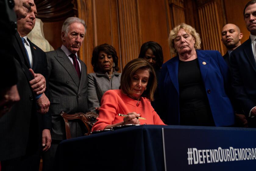 WASHINGTON, D.C. - JANUARY 15: Speaker of the House Nancy Pelosi (D-CA) signs the articles of impeachment during an engrossment ceremony with impeachment managers House Judiciary Committee Chairman Jerrold Nadler (D-NY) and House Intelligence Committee Chairman Adam Schiff (D-CA) standing beside her in the Rayburn Room at the U.S. Capitol on Wednesday, Jan. 15, 2020 in Washington, D.C. Trump's Senate trial expected to begin on Tuesday. (Kent Nishimura / Los Angeles Times)