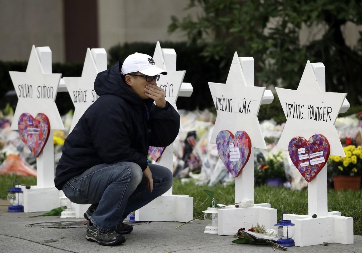 A person pauses in front of Stars of David with the names of those killed in a deadly shooting at the Tree of Life Synagogue, in Pittsburgh, Oct. 29, 2018.