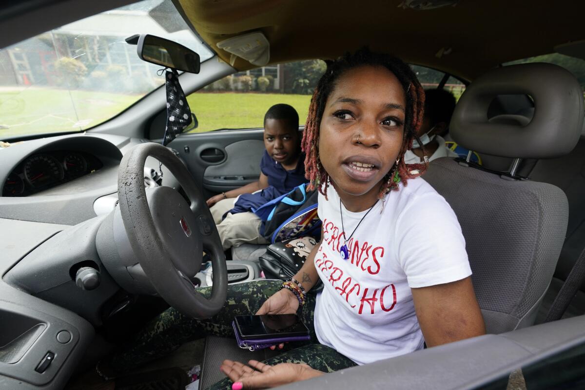 Syreeta Tatum, right, speaks about the disappointment her children expressed at having to again undertake virtual learning classes due to the city's water issues that forced Jackson Public Schools to close for several days, Tuesday, Sept. 6, 2022, in Jackson, Miss. Tatum says her eldest son, Warren Tatum III, 10, left, looked forward to returning back to the structure of his classes at Spann Elementary School and working with his teachers. (AP Photo/Rogelio V. Solis)