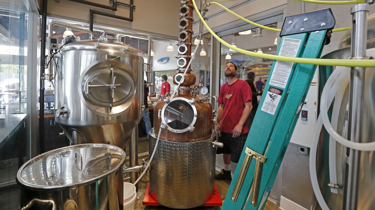 Jim Clarke, right, head brewer and distiller for Left Coast Brewing Co.’s Irvine location.