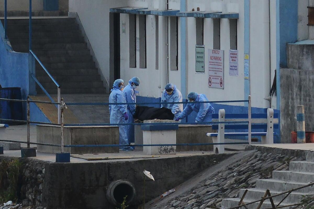 Medical staff prepare to cremate a body on the outskirts of Siliguri, India, on March 30.