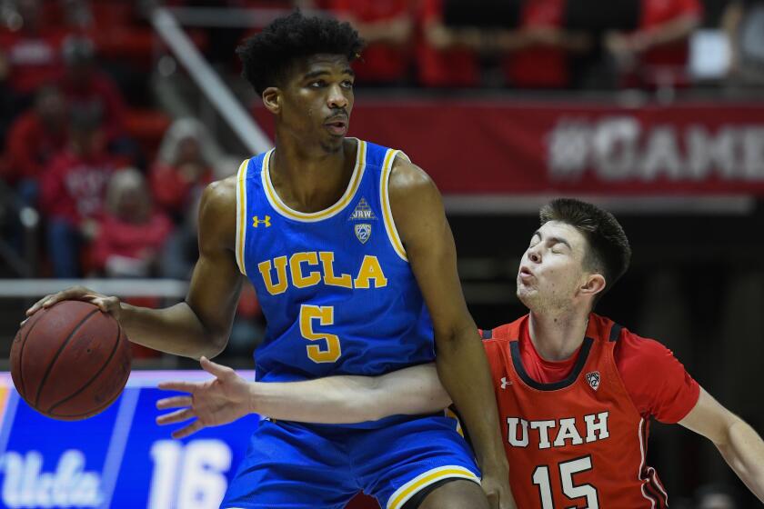 UCLA guard Chris Smith (5) looks to dribble around Utah guard Rylan Jones (15) during the first half of a game Feb. 20 at the Jon M. Hunstman Center.