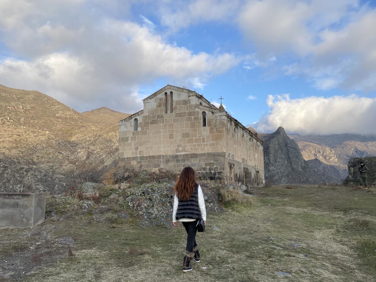 A woman walks toward a stone monastery in Nagorno-Karabakh — known as Artsakh to Armenians.