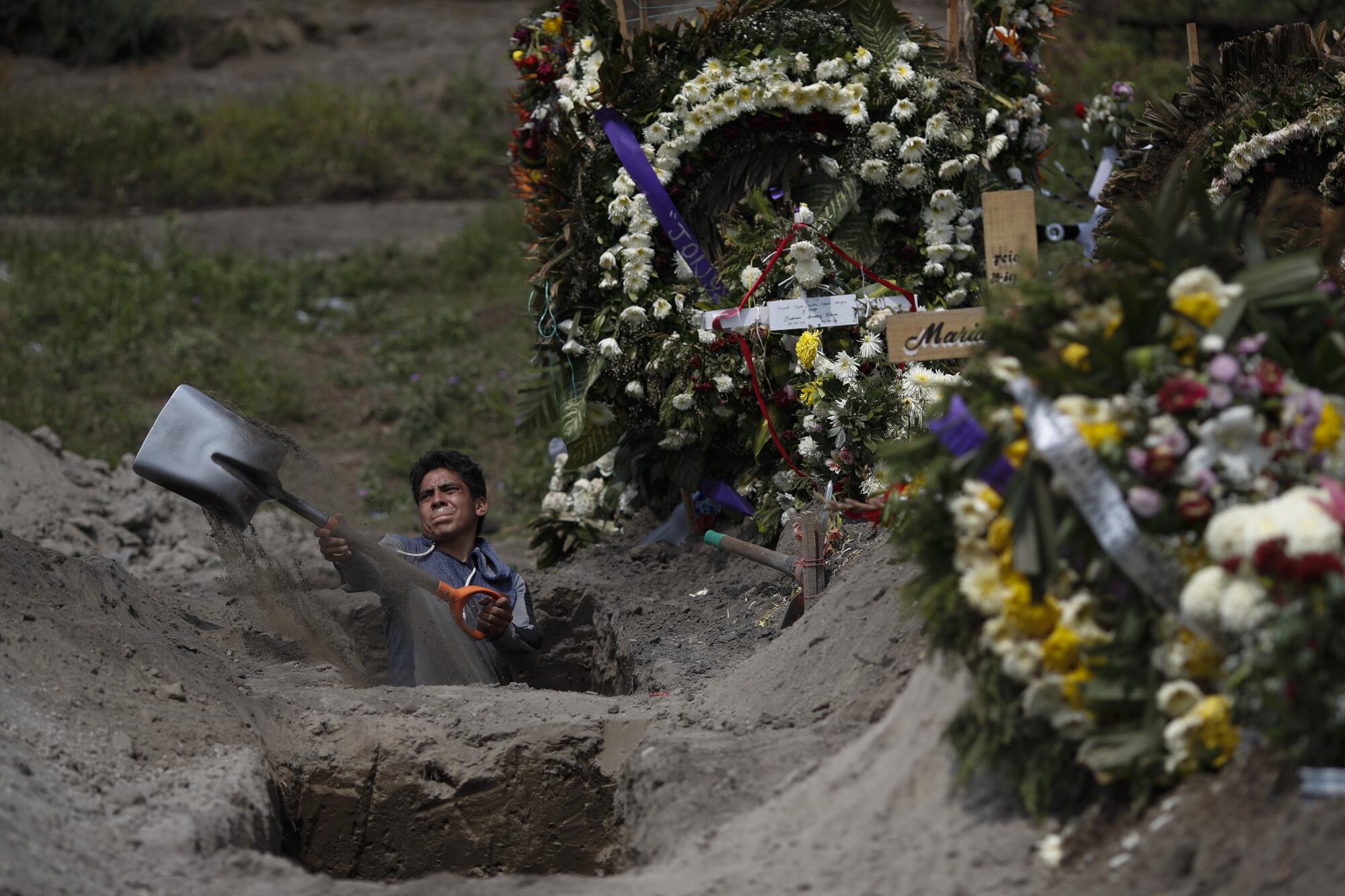 A cemetery worker digs a grave in Mexico City