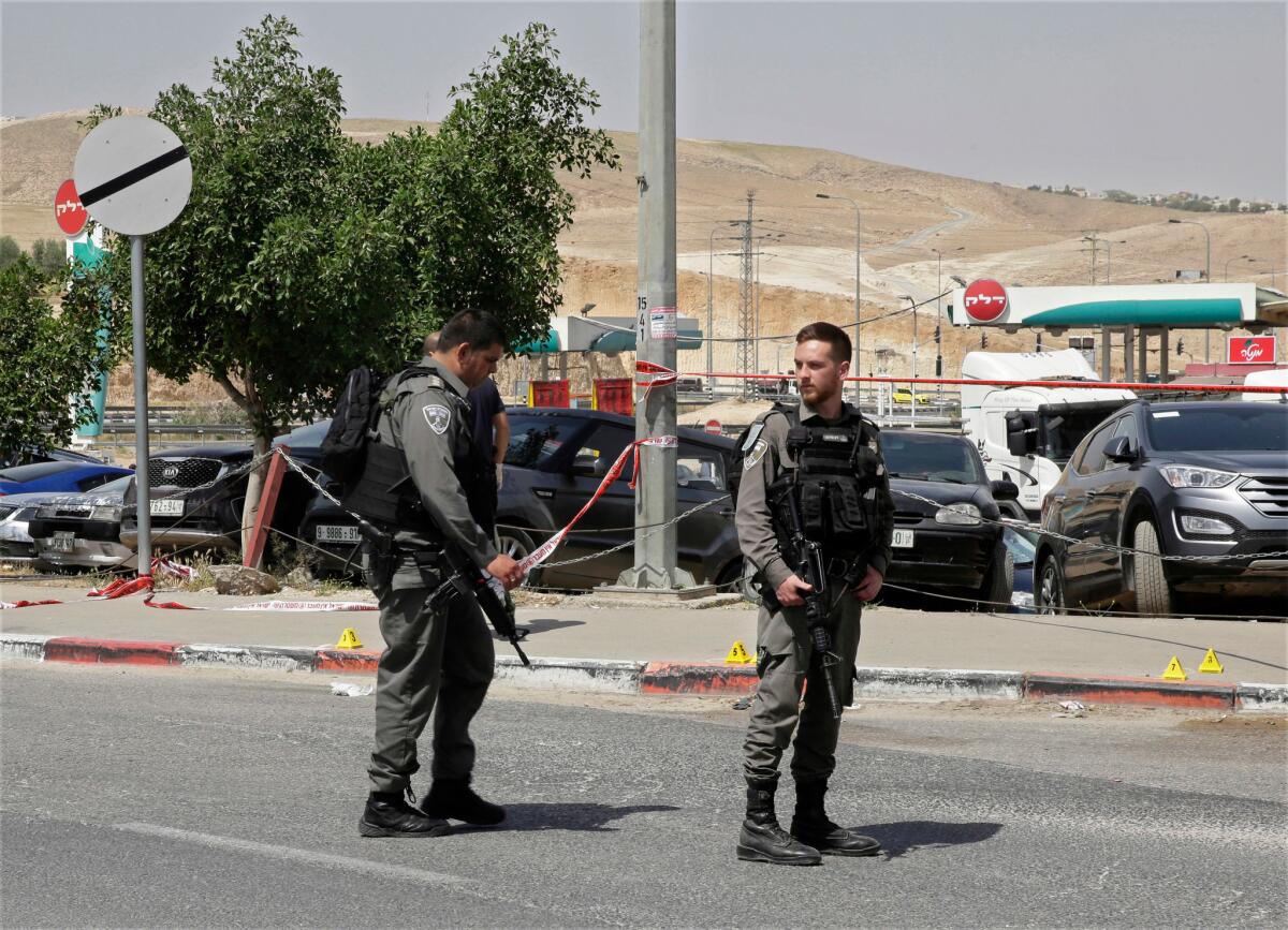 Agentes de la policía de Israel hacen guardia en el lugar donde un palestino intentó apuñalar a un israelí con una herramienta antes de ser abatido por un civil israelí, cerca del asentamiento de Mishor Adumim, en Cisjordanis, el 8 de abril de 2018.