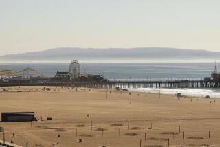 Pedestrians  walk on the Santa Monica Pier. 