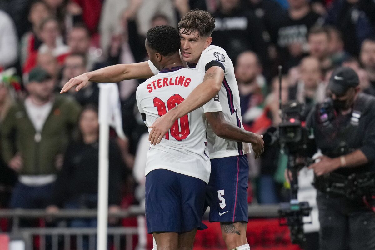 England's John Stones, right, is congratulated by teammate Raheem Sterling after scoring his team's first goal during the World Cup 2022 group I qualifying soccer match between England and Hungary at Wembley stadium in London, Tuesday, Oct. 12, 2021. (AP Photo/Kirsty Wigglesworth)