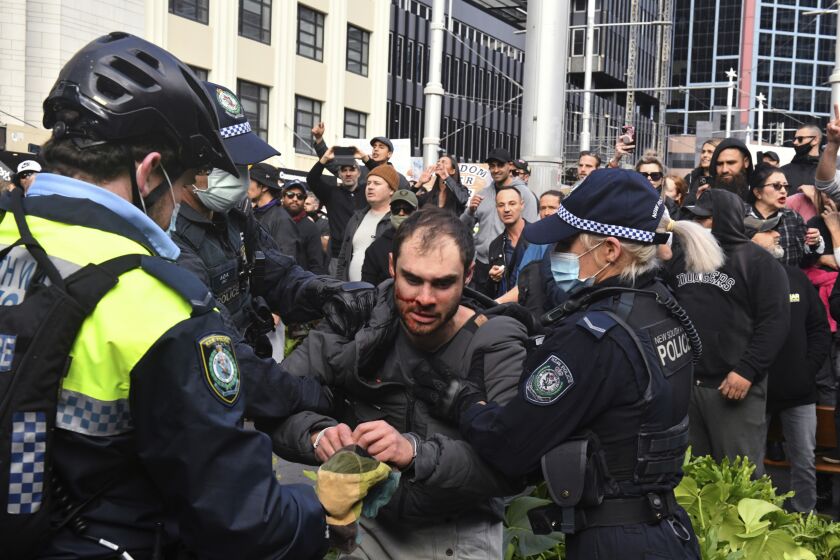 A protester, center, is arrested by police at a demonstration at Sydney Town Hall during a 'World Wide Rally For Freedom' anti-lockdown rally in Sydney, Saturday, July 24, 2021. (Mick Tsikas/AAP Image via AP)