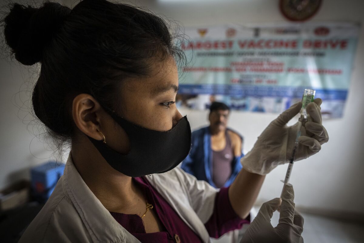 A nurse prepares to administer vaccine for COVID-19 at a private vaccination center in Gauhati, India, Sunday, April 10, 2022. India began offering booster doses of COVID-19 vaccine to all adults on Sunday but limited free shots at government centers to front-line workers and people over age 60. (AP Photo/Anupam Nath)