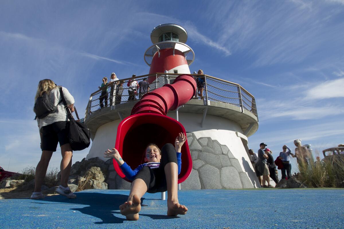 Ava Collins, 9, tries out a new slide at the playground during the grand opening of Marina Park on Saturday.