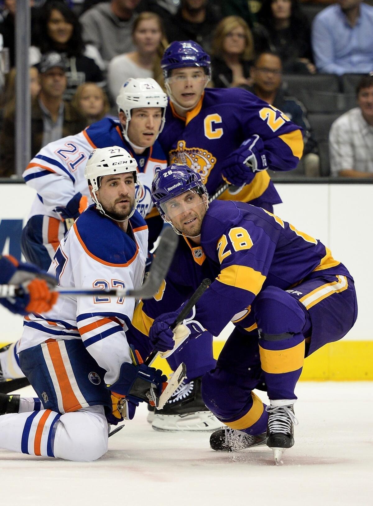 Kings center Jarret Stoll, right, battles Edmonton Oilers forward Boyd Gordon for a loose puck during a game on Oct. 27. Stoll suffered an upper-body injury in the Kings' loss to the Nashville Predators on Saturday.