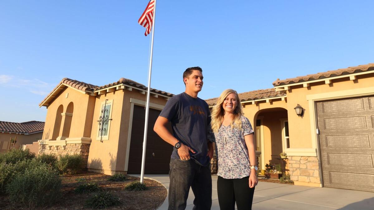 Josh and Kayleigh Hyink, former San Clemente residents, pose in front of the new home they recently purchased in the Riverside County community of Murrieta.