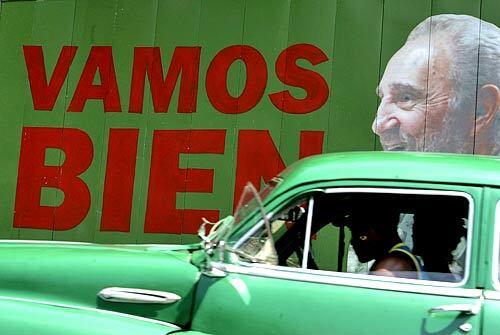 A car passes in front of a billboard of Cuban President Fidel Castro that states, "We're doing well." Yet Cuba is falling apart — literally. Though there are high-profile restoration projects in Old Havana, the country's structural decay seems to worsen each month.