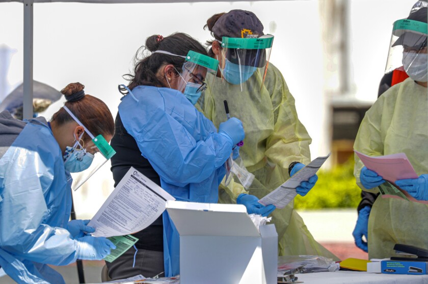 San Bernardino County Department of Public Health employees work at a drive-through cornonavirus testing site.
